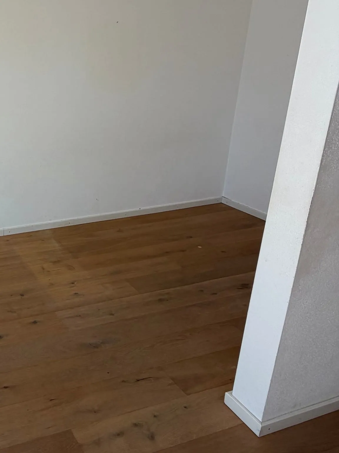 Die geräumte Nische mit weissen Wänden, Holzdielen und dem Wandvorsprung rechts im Vordergrund